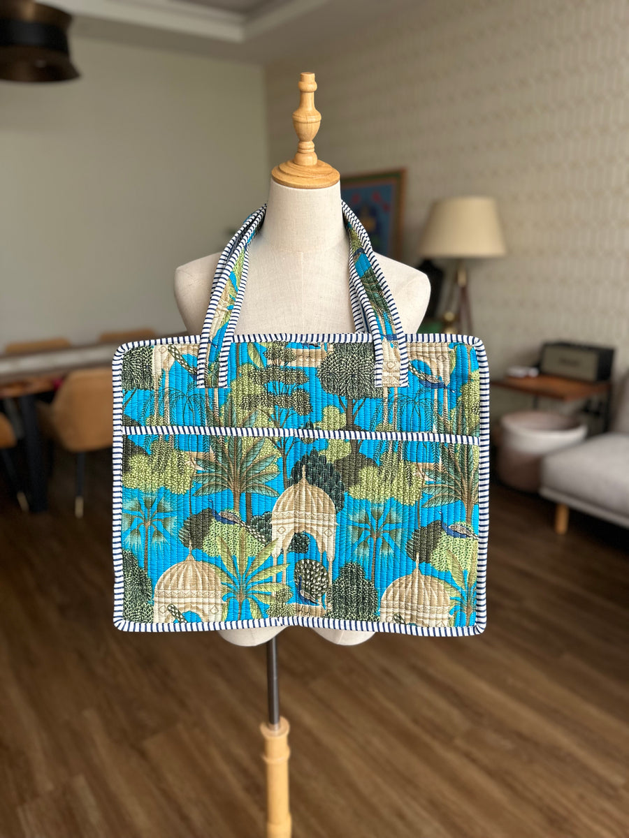 Tote bag with a blue and green tropical shell and palm tree pattern.